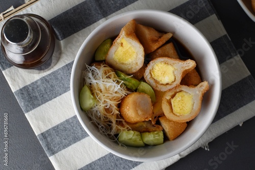 Pempek on white plate with vermicelli and cuko sauce. Pempek, mpek-mpek or empek-empek is a savory Indonesian fishcake delicacy, made of fish and tapioca, from Palembang, South Sumatera, Indonesia.