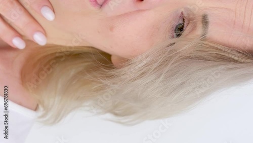 slow motion seasonal allergy cold dry air close-up woman sneezes covering her hand on white background watery eyes licks lips unpleasant sensation photo