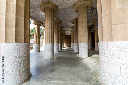 Front perspective of hall with columns with fragments of tiles and ceiling with small domes, Hypostyle room in Park Güell by Antoni Gaudí, sightseeing day in Barcelona, Catalonia Spain photo