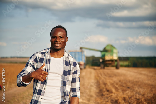 Showing thumb up. Beautiful African American man is in the agricultural field