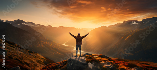 Man with arms up celebrating on top of the mountains - Hiker enjoying freedom on a hill at sunset - Freedom, sport, success and mental health concept photo
