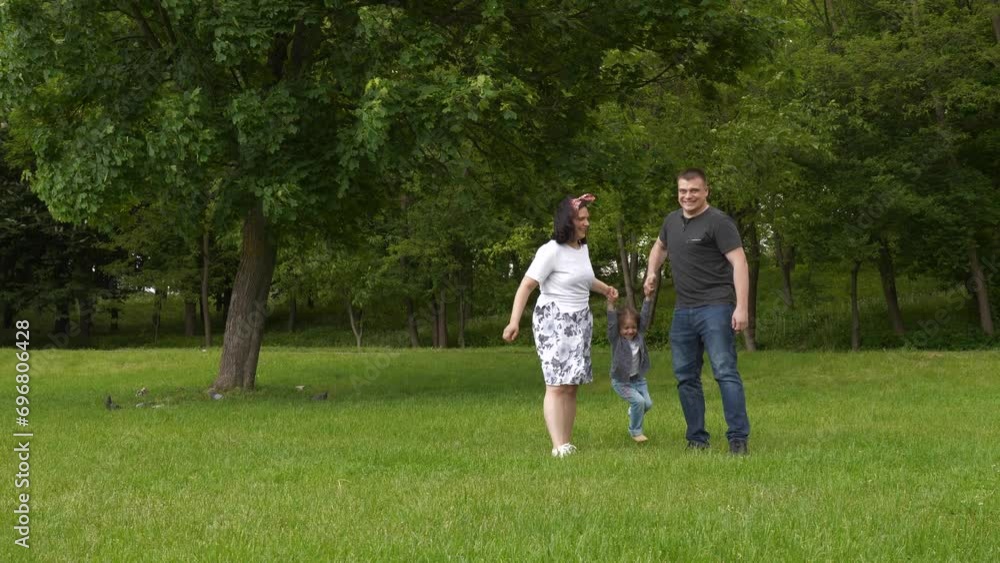 Happy family and little daughter enjoing and laughing on International Father's Day in summer green park outdoor Happy family and little daughter enjoing and laughing on International Father's Day in summer green park outdoor