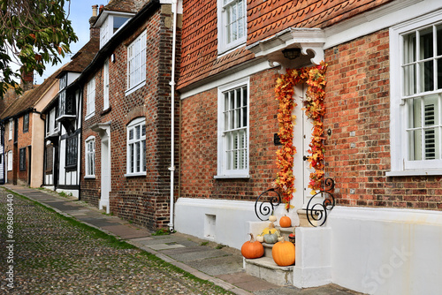 Halloween decorated front door with various size and shape pumpkins. 