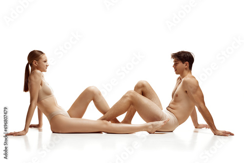 Cuadro en lienzo Couple, naked man and woman dressed in underwear sitting across from each other and making cute eye contact against white background