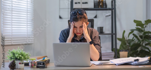 Puzzled confused asian woman thinking hard concerned about online problem solution looking at laptop screen, worried serious asian businesswoman focused on solving difficult work computer task photo