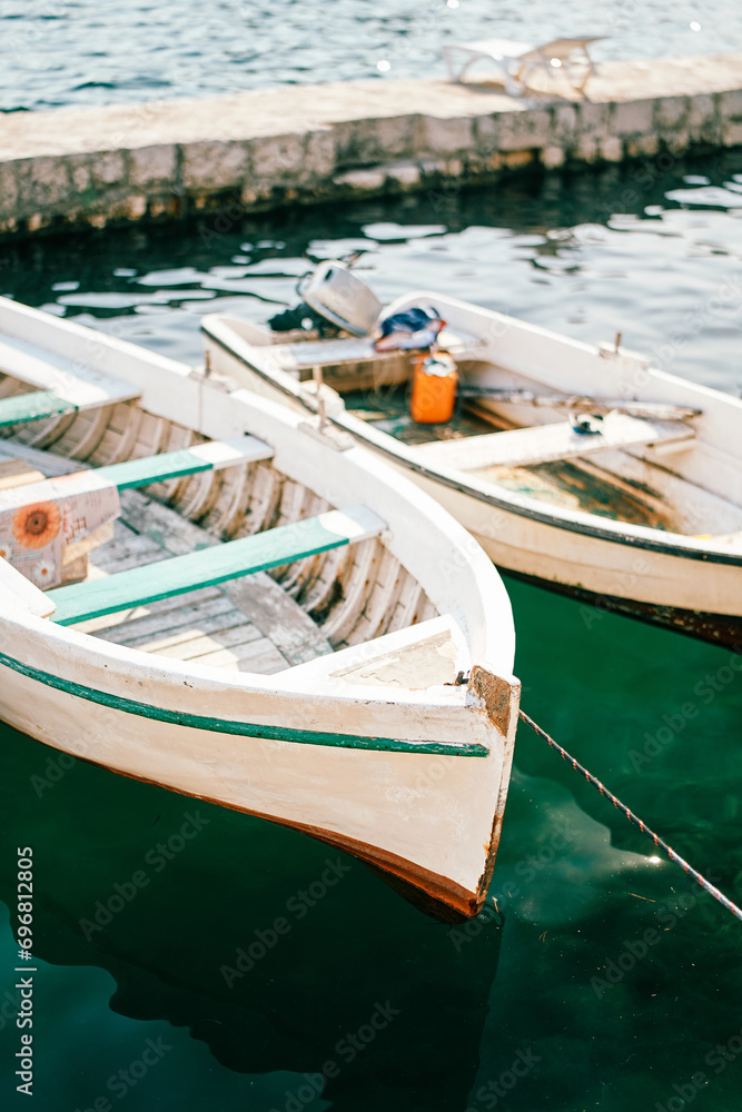 White wooden fishing boats are moored at the pier
