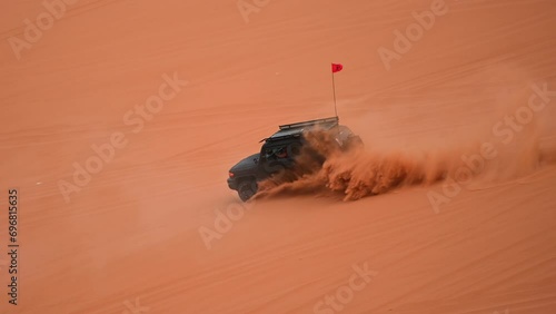 Riyadh, Saudi Arabia – November 1st 2023: Offroad vehicles bashing and climbing desert safari dunes ,red sand dunes adventurous ride 4x4 vehicle in Riyadh. Modified car, customized vehicle photo