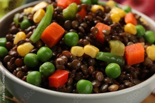 Delicious lentils with vegetables in bowl, closeup photo