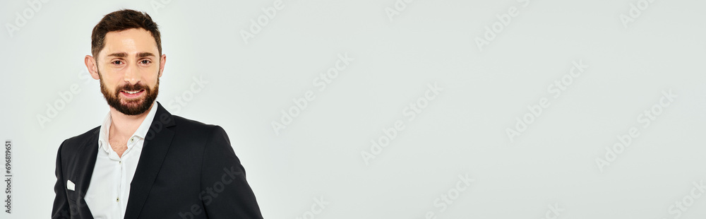 portrait of happy and elegant bearded businessman in black suit smiling at camera on grey, banner portrait of happy and elegant bearded businessman in black suit smiling at camera on grey, banner