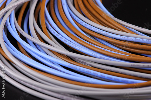 Electrical installation wires in colored insulation on a dark background. Close-up.
