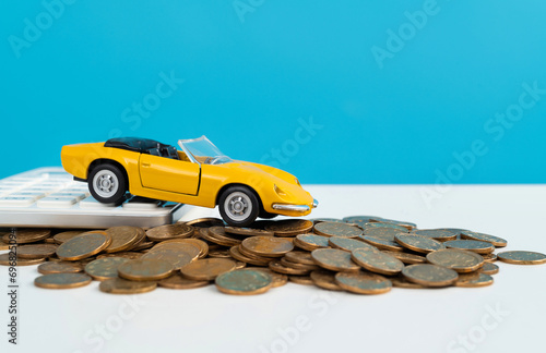 Car model and calculator on heap of coins © xy