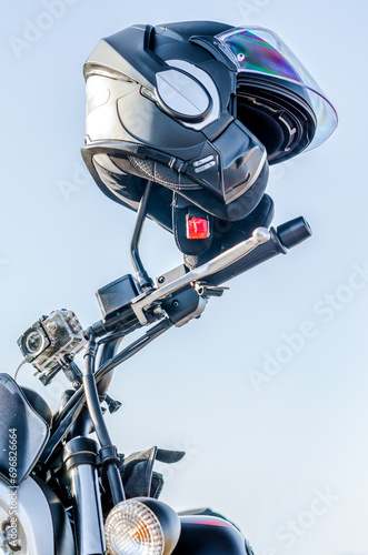motorcycle helmet on a motorcycle rudder on a blue sky background