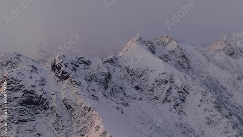 The winter charm of Mount Norway Lofoten, where a snow-covered mountain peak stands against the cold backdrop of clear blue skies. photo