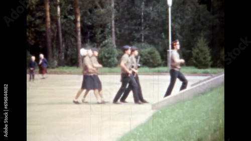 Pioneer children salute to soldiers of Second World War memorial. People soldier marching, saluting. Military holiday. Patriotism in remember, honor. Retro archival film. 1980s Russia. Vintage archive photo