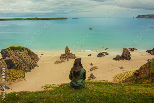 Exploring NC500's Top Beaches: A Gazing Girl on a Cliff, Embracing Scotland's Azure Sea Along the NC500 Route, Including Sango Sands, Balnakeil, and Achmelvich Beaches