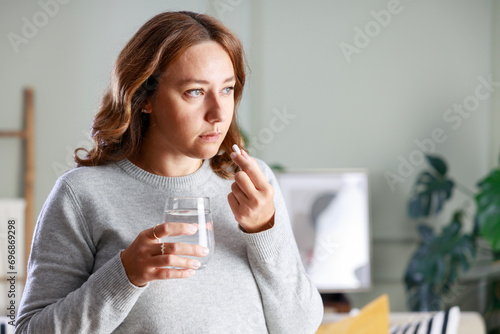 Young woman taking pill