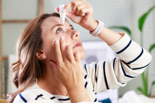Young woman putting eye drops