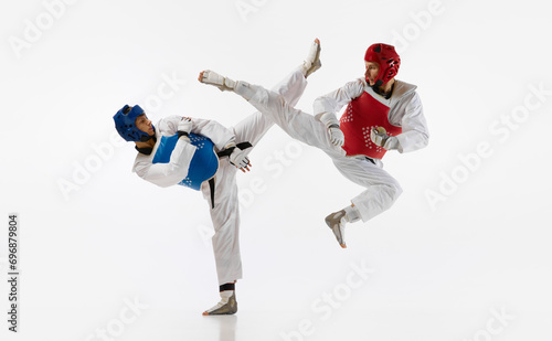 Εκτύπωση καμβά Athletic, strong young men, taekwondo athletes in motion, fighting, training isolated over white background