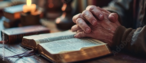 A praying man leans over a Bible in a moment of spiritual reflection and devotion photo