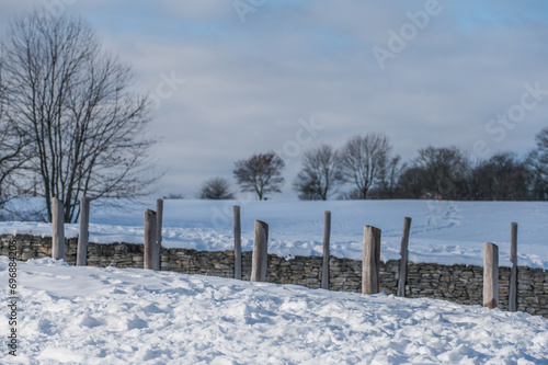 Holzbohlen mit Schutzmauer im Schnee an keltischem Zangentor am Heidengraben in Erkenbrechtsweiler auf der schwäbischen Alb	
 photo