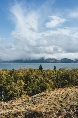 amazing beautiful top view of blue sevan lake in armenia with autumn trees below and vegetation with fluffy white clouds around photo