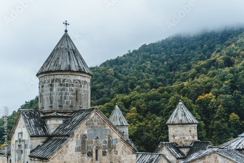 view of Haghartsin Monastery Complex over beautiful autumn forest on rainy day with low clouds in nature armenia dilijan park