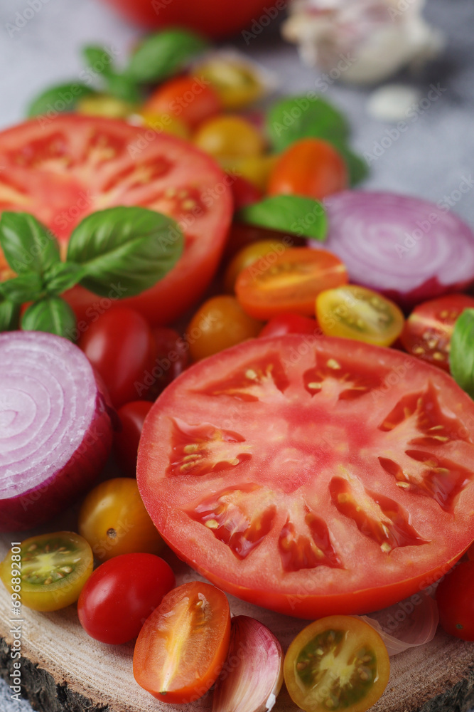 Flat lay composition of different tomatoes, onion, basil and garlic Flat lay composition of different tomatoes, onion, basil and garlic