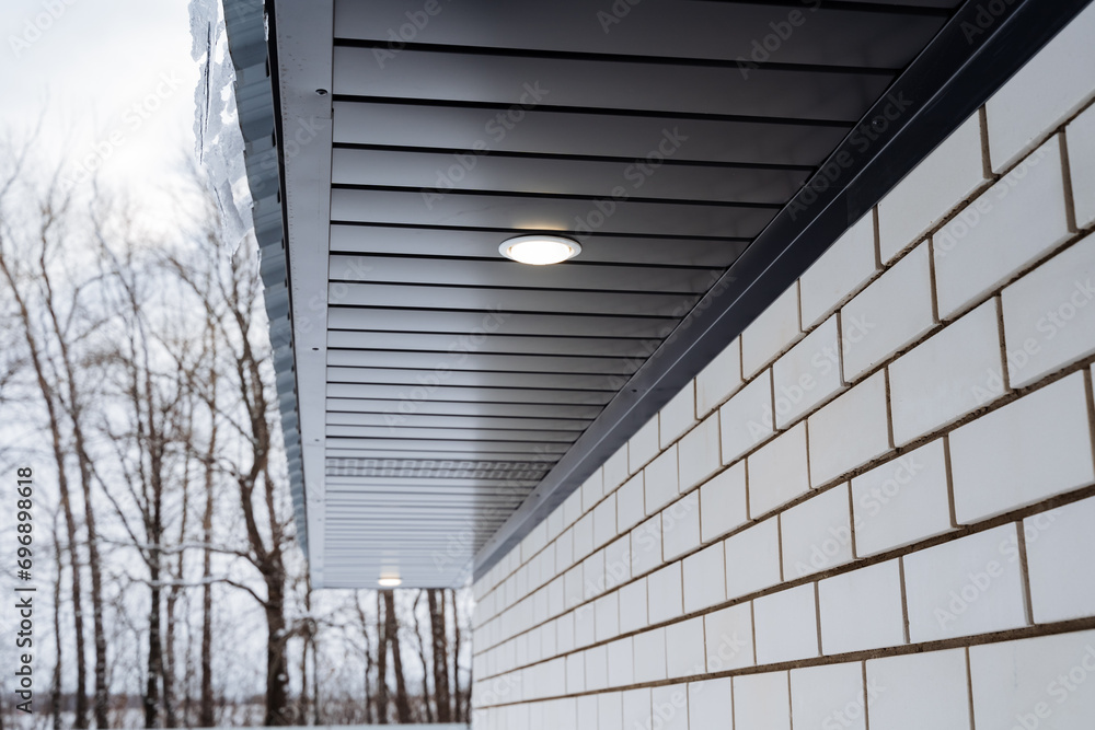 Obraz premium Street lighting, spot lighting on the roof of the house, country house, roof gable.