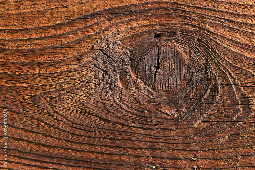 Fototapeta premium Brązowa chropowata drewniana deska z widocznymi słojami i sękiem - tło
