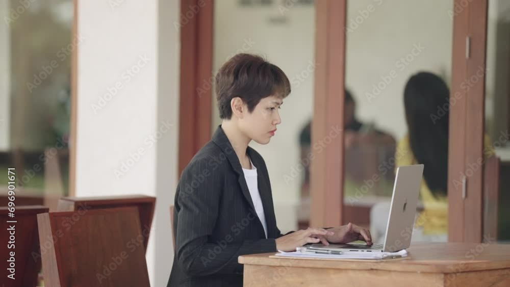 The image portrays a businesswoman working diligently in her office, focused on her laptop amidst a professional setting The image portrays a businesswoman working diligently in her office, focused on her laptop amidst a professional setting