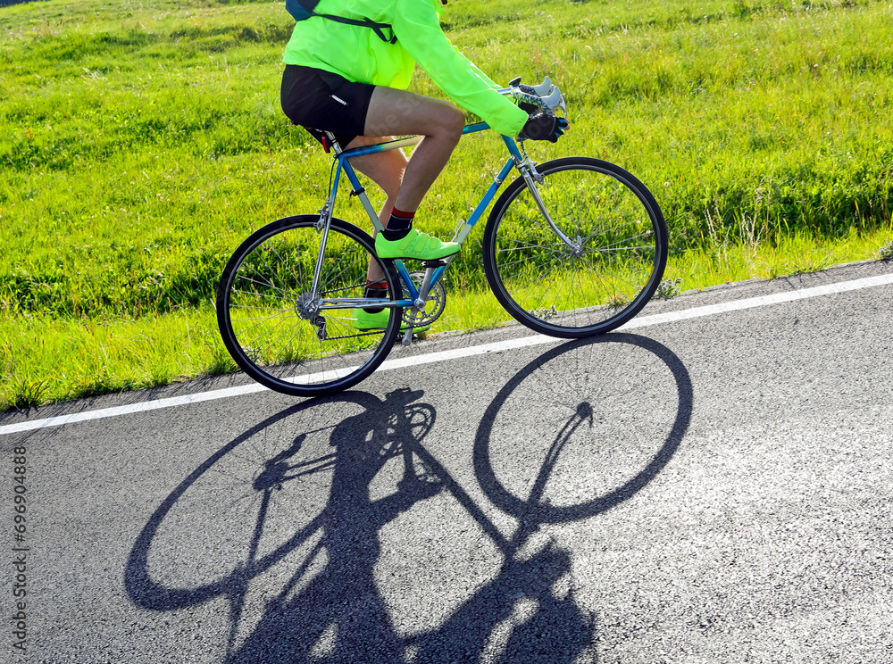 Fototapeta premium cyclist with racing bicycle and phosphorescent waterproof jacket