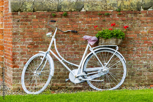 Dutch white bike with flower basket filled with red geranium flowers