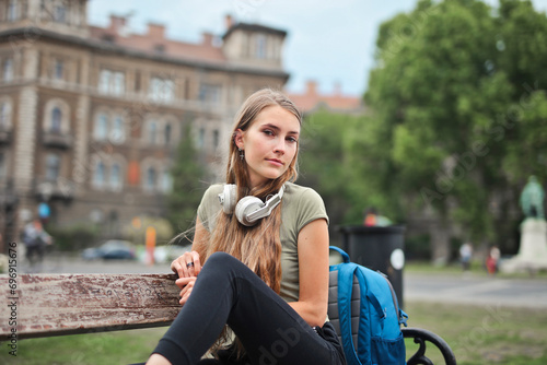 young woman sitting on a bench in the city