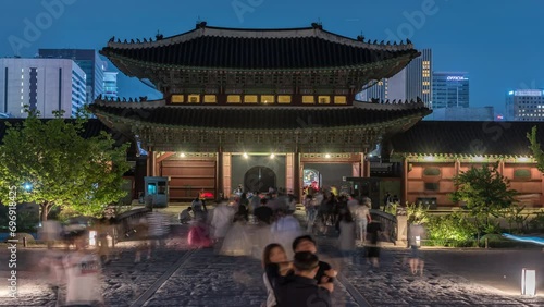 Time-Lapse of Travel are walking in Gyeongbokgung Palace At Night In South Korea, with the name of the palace 'Gyeongbokgung' on a sign .