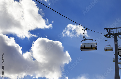Chair-lift and blue sky with sunlight clouds