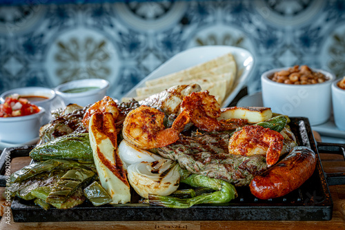 Parrillada de Sonora -Northern-style mixed grill with carne asada steak, mesquite chicken breast, chorizo links, spicy shrimp, Asadero cheese, cactus
paddles, grilled onions, and chile toreado photo