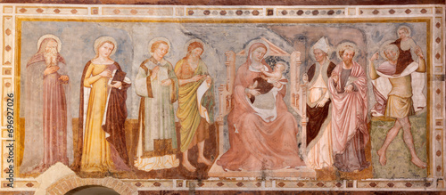 TREVISO, ITALY - NOVEMBER 4, 2023: The fresco of Madonna among the saints in the church Chiesa di San Francesco by Tommaso da Modena (1350).