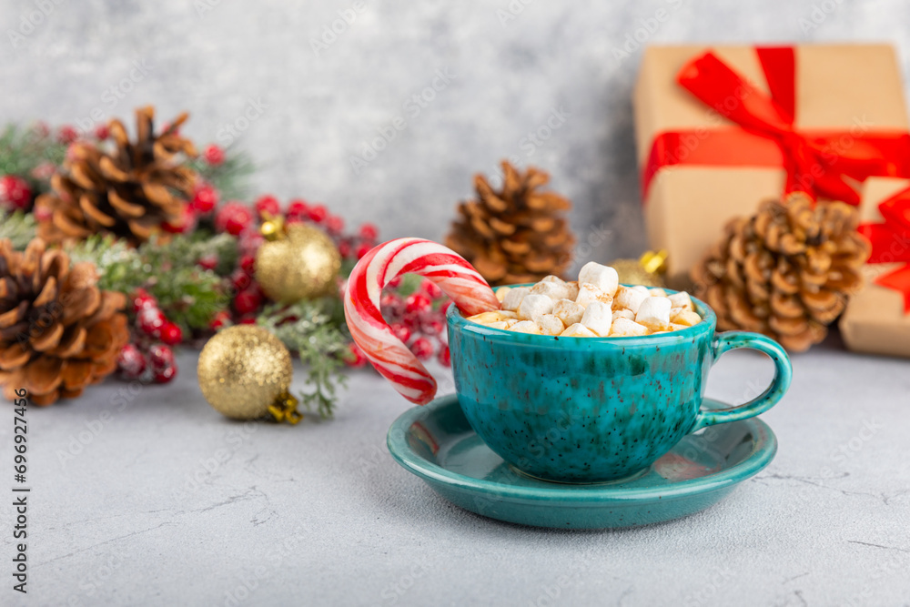 Hot drink with marshmallows and candy cane in blue cup on texture table.Cozy seasonal holidays.Hot cocoa with gingerbread Christmas cookies.Hot chocolate with marshmallow and spices.Copy space. Hot drink with marshmallows and candy cane in blue cup on texture table.Cozy seasonal holidays.Hot cocoa with gingerbread Christmas cookies.Hot chocolate with marshmallow and spices.Copy space.
