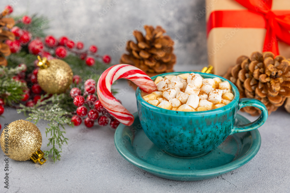 Hot drink with marshmallows and candy cane in blue cup on texture table.Cozy seasonal holidays.Hot cocoa with gingerbread Christmas cookies.Hot chocolate with marshmallow and spices.Copy space. Hot drink with marshmallows and candy cane in blue cup on texture table.Cozy seasonal holidays.Hot cocoa with gingerbread Christmas cookies.Hot chocolate with marshmallow and spices.Copy space.