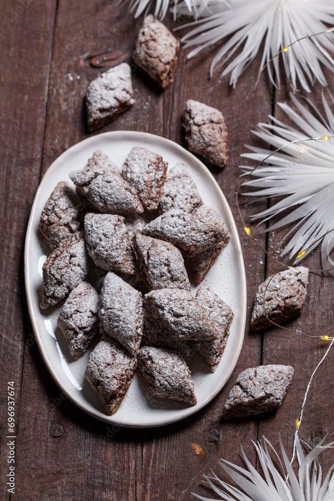 Italian Christmas cookies Castagnelle with almonds, cocoa and egg whites on a wooden background. Gluten free cookies.