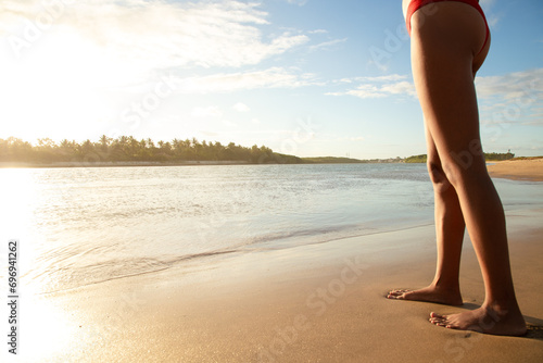 Woman's legs on beach sand during setting sun