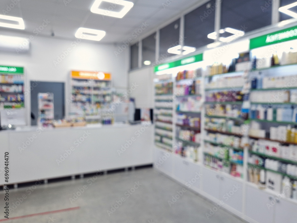 Blurred view inside a pharmacy with stocked shelves. Healthcare and cosmetics industry defocused background
