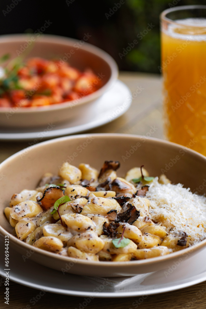 Pappardelle pasta with mushrooms and parmesan cheese on a plate . Traditional Italian gnocchi pasta with mushroom and parmesan cheese Pappardelle pasta with mushrooms and parmesan cheese on a plate . Traditional Italian gnocchi pasta with mushroom and parmesan cheese