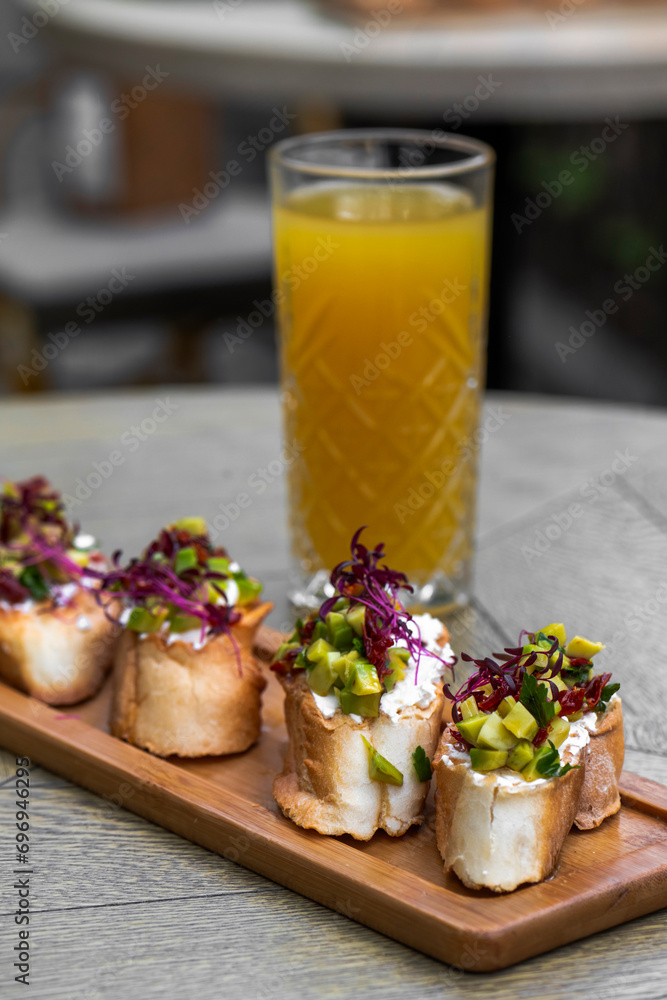 Canapes with avocado, mozzarella cheese and sauce on wooden board . bruschetta Canapes with avocado, mozzarella cheese and sauce on wooden board . bruschetta