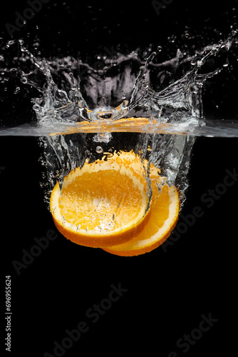 Sliced orange fall into water