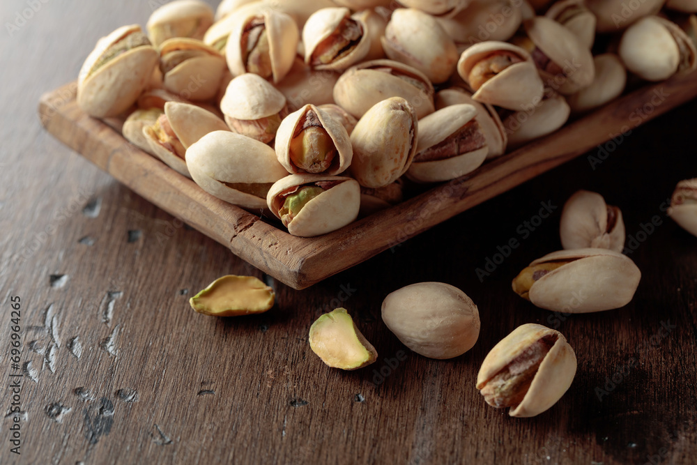 Salted pistachios on an old wooden table.