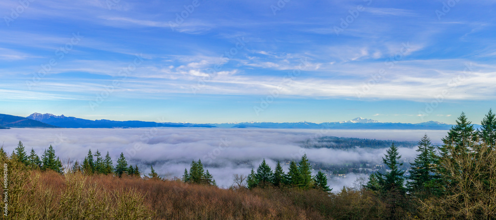 Panoramic view of cloud inversion over valley with alpine mountains visible on far horizon. Panoramic view of cloud inversion over valley with alpine mountains visible on far horizon.
