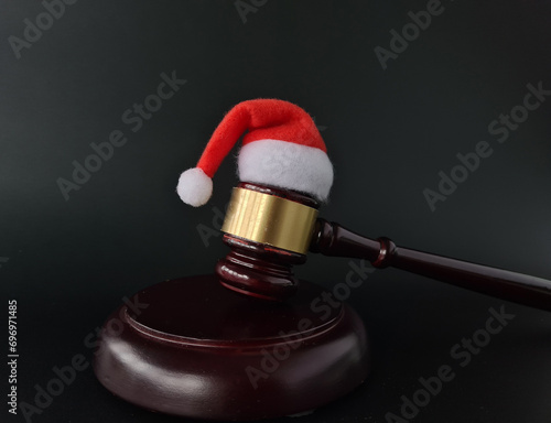 Santa Claus hat on Judge Gavel on wooden rustic background