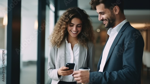 Cheerful and smiling young successful female businesswoman and man standing with a colleague photo