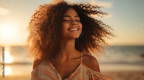 Gleeful Latina lady unwinding on shore with shut lids during sundown, lovely biracial lady relishing breeze playing with locks, delightful youthful lady inhaling ocean breeze at warm beach.
